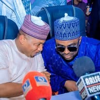 Hon. Umar Yusuf Yabo in a patterned cap at a press briefing, surrounded by microphones bearing Nigerian broadcast network logos.